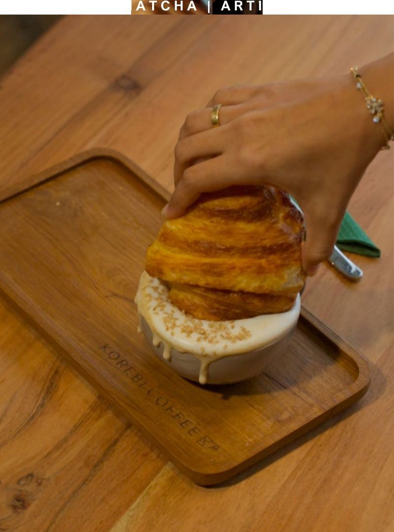Butter croissant torn and dipped into a matcha latte