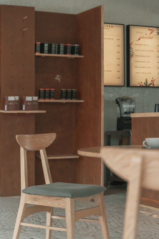 Dining table with corten shelving and menu boards in the background, Mumatpura, Ahmedabad